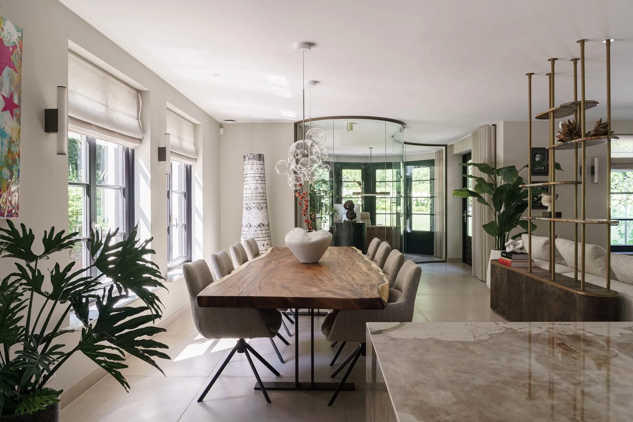 Eetkamer van Villa Boge met massief houten tafel en glazen bollenluchter